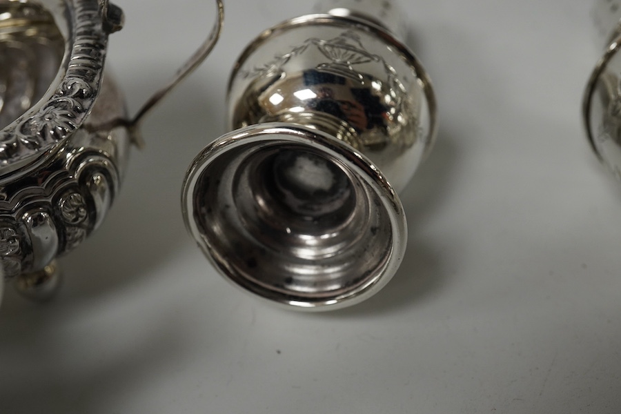 A set of four late Victorian embossed silver two handled salts, Birmingham, 1896, 98mm and a pair of silver peppers. Condition - fair to good